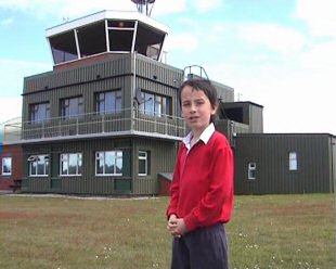 Alex beside the control tower at Woodvale