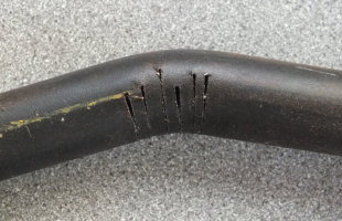 Saw-cuts part way through steel bar in order to bend it prior to welding Saw-cuts part way through steel bar in order to bend it prior to welding